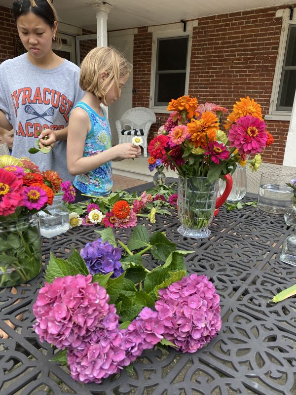 stunning colors of flowers being arranged. on a hot day at the patio table