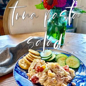 Tuna Pasta Salad served with cucumber slices and Rita crakers with zinnias in vlue Bell jar on the table