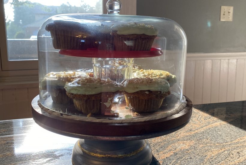 carrot cupcake in cake stand with glass cover