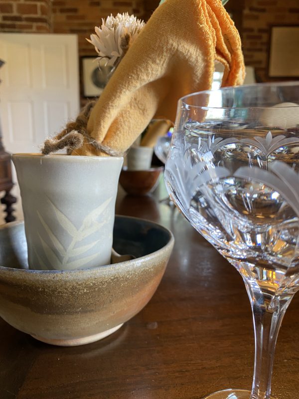 Place Setting for Rustic Autumn Tablescape with crystal wine glass, pottery bowl adn gold napkin