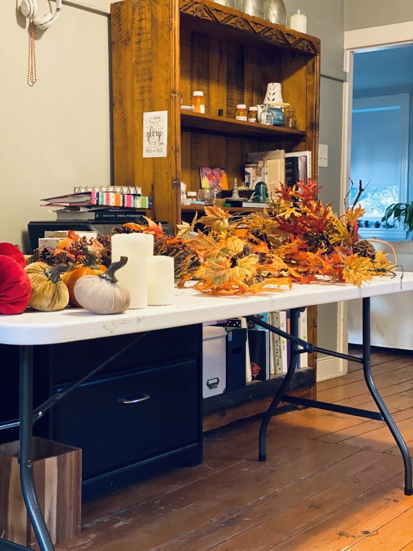 Table with decorating elements with leaves, candles and velvet pumpkins