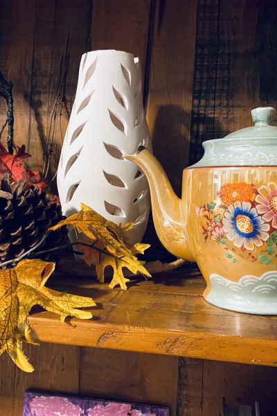 Tea Pot Close Up on shelf with white vase and leaves